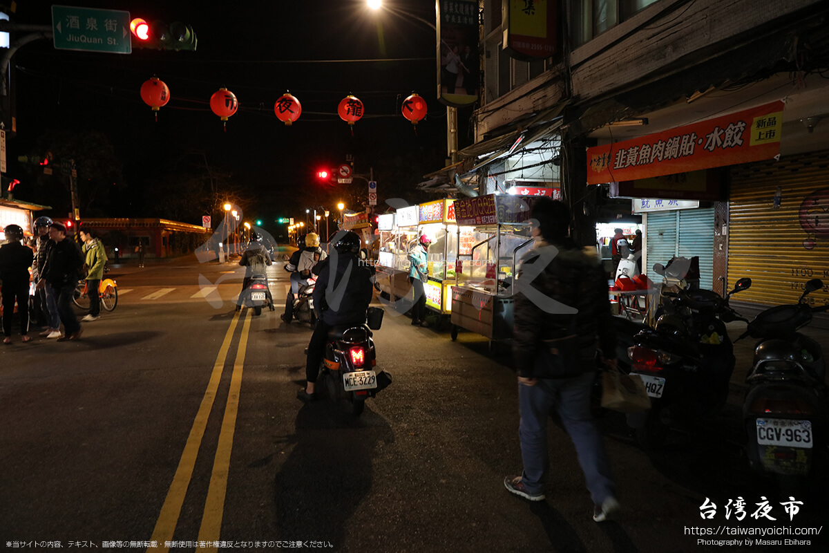 夜市の中を走るバイク